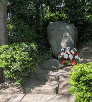Sicht auf den Gedenkstein von Friedrich Küter im Volkspark Mariendorf, mit einem Kranz der SPD-Abteilung Mariendorf